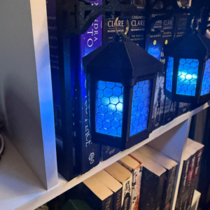 Blue glowing six-sided shelf lantern beneath a knight-themed bracket